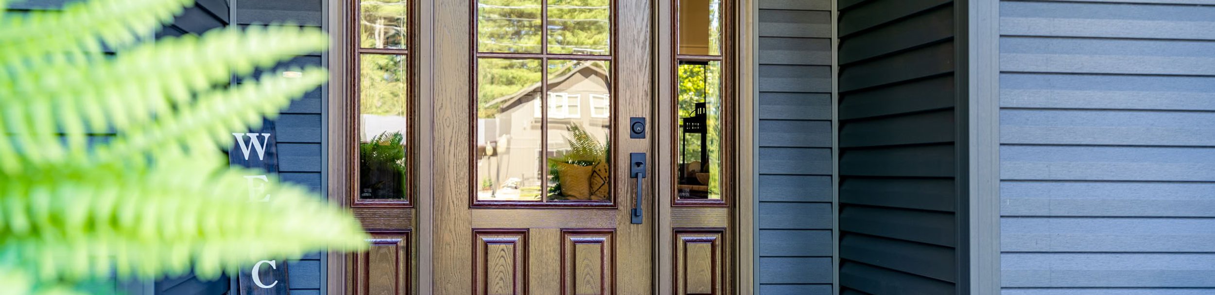 Wood front door with glass panels and surrounding sidelights.