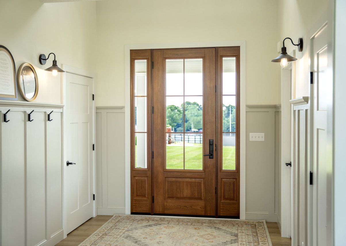 Wood front door with glass, white wainscoting entryway interior.